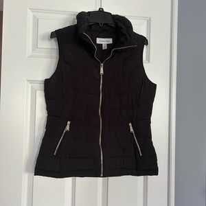 Black vest with gold zippers.